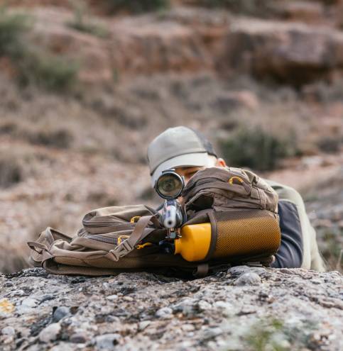 Hunter aiming with rifle in natural setting